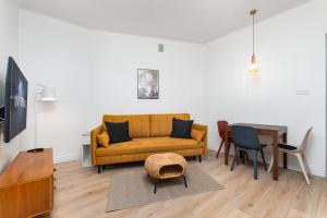 un soggiorno con divano giallo e tavolo di Apartament Plac Konstytucji by Your Freedom a Varsavia