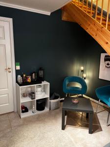 a room with a blue chair and a staircase at Liten kjellerleilighet. Landlig rolig område. in Tromsø