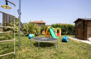 a small playground with a trampoline and a slide at Blu loft in Salemi