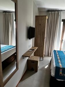 um quarto com um espelho, uma cama e uma secretária em Quarto em Quinta Santa Bárbara Ecoresort em Pirenópolis