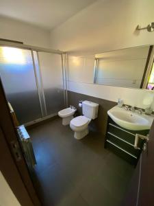 ein Badezimmer mit 2 WCs, einem Waschbecken und einem Spiegel in der Unterkunft ENCANTO DE CHACRAS- Moderna-A metros de la plaza in Chacras de Coria