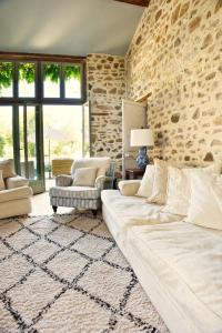a living room with a couch and a stone wall at Les Picardies in Lesterps +42 photos