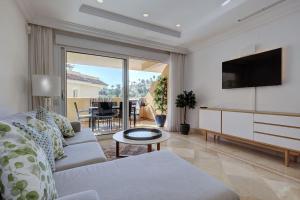 - un salon avec un canapé et une télévision dans l'établissement Stunning 2 Bedroom Apartment in Aloha Hill Club, à Marbella