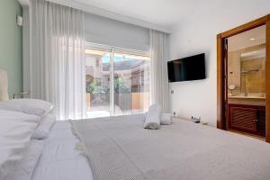 - une chambre blanche avec un grand lit et une fenêtre dans l'établissement Stunning 2 Bedroom Apartment in Aloha Hill Club, à Marbella