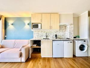 ein Wohnzimmer mit einem Sofa und einer Küche in der Unterkunft Cannes - Appartement rénové avec vue mer imprenable in Cannes