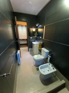 ein Badezimmer mit Toilette und Waschbecken in der Unterkunft ENCANTO DE CHACRAS- Moderna-A metros de la plaza in Chacras de Coria + 48 Fotos