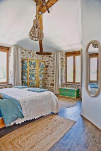 1 dormitorio con cama y pared de piedra en Les Picardies, en Lesterps