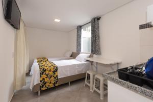 a small bedroom with a bed and a table at Apto Bela Vista São Paulo in Sao Paulo