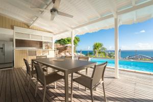 een eetkamer met een tafel en stoelen op een terras bij Villa Alexandra in Saint-François