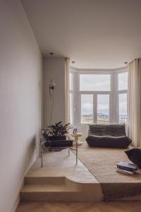 a living room with a couch and a large window at DUNE DU PALACE in Zeebrugge