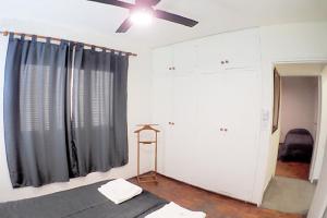 Schlafzimmer mit einem Bett und einem Deckenventilator in der Unterkunft Departamento Bouquet in Barraquero