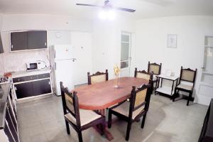 eine Küche und ein Esszimmer mit einem Holztisch und Stühlen in der Unterkunft Departamento Bouquet in Barraquero
