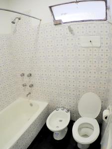 a bathroom with a toilet and a bath tub at Departamento Bouquet in Barraquero