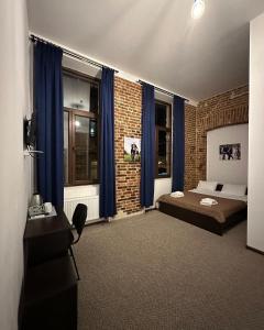 ein Schlafzimmer mit einem Bett und einer Ziegelwand in der Unterkunft Hotel Rover in Lwiw