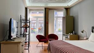 Un dormitorio con dos sillas rojas y una cama. en Casa dos Lóios by Shiadu, en Oporto