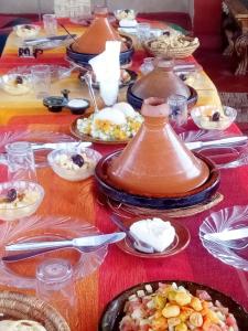 a table with many plates of food on it at Kasbah Dar Dmana in Skoura +66 photos