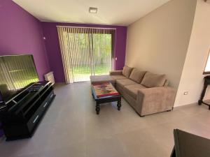 ein Wohnzimmer mit Sofa und Tisch in der Unterkunft ENCANTO DE CHACRAS- Moderna-A metros de la plaza in Chacras de Coria