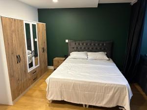 Un dormitorio con una cama grande y una pared verde. en Prime İstanbul Residances Deluxe King Studio, en Estambul