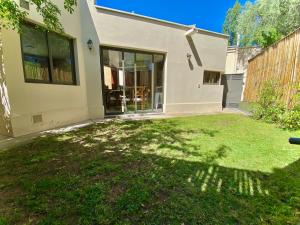 ein Haus mit einem Rasen davor in der Unterkunft ENCANTO DE CHACRAS- Moderna-A metros de la plaza in Chacras de Coria