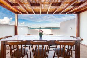 uma sala de jantar com uma grande mesa e cadeiras em Tríplex para 9 pessoas na cobertura do Pirangi Prime por Carpediem em Parnamirim