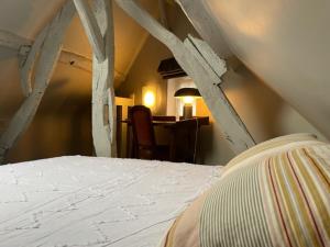 een slaapkamer met een wit bed in een kamer bij La maison St Jean in Honfleur