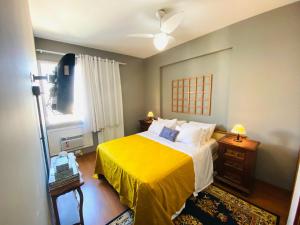 a bedroom with a bed with a yellow blanket at Leblon Apartamento de 2 Quartos com Vista do Mar, piscina, sauna e garagem in Rio de Janeiro