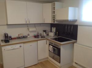 uma pequena cozinha com armários brancos e um lavatório em EBH HOME em Filderstadt