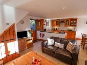 a living room with a couch and a kitchen at Hayloft Cottage in Staintondale