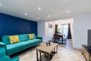 a living room with a blue couch and a table at Prestbury Road in Cheltenham