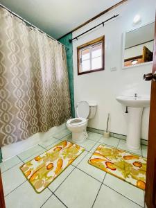 a bathroom with a toilet and a sink at Lamanai Riverside Retreat in Orange Walk