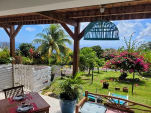 聖呂斯的住宿－appartement privé ECO-RESPONSABLE, magnifique vue sur la mer des Caraibes et jardin clos, WiFi, à 2mn de la plage，天井设有木制凉亭和桌子