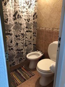 a bathroom with two toilets and a black and white shower curtain at Los Manzanos in Villa Ciudad Parque +13 photos