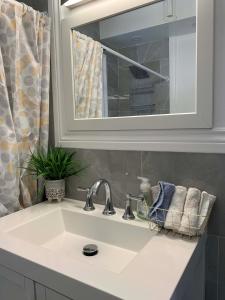 a bathroom sink with a mirror and a sink at The Horseshoe Falls Villa in Niagara Falls