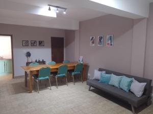 sala de estar con mesa, sillas y sofá en Casa pura vida en General Roca