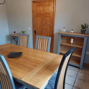 Large private detached home في Dungiven: طاولة طعام مع كراسي وطاولة خشبية
