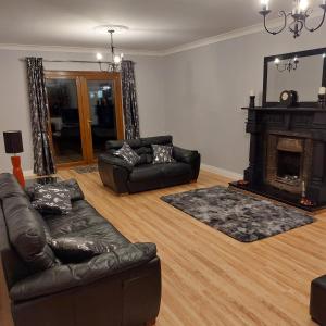 Large private detached home في Dungiven: غرفة معيشة مع أريكة ومدفأة