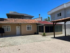 a house with a driveway in front of it at Casa em Bombinhas Praia do Mariscal in Bombinhas