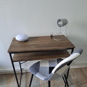 un bureau en bois avec une lampe et une chaise dans l'établissement Studio de charme, à Saint-Maixent-lʼÉcole