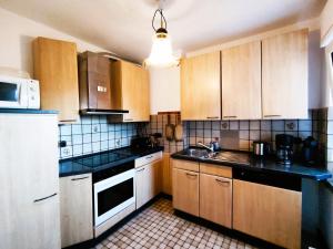 a kitchen with white appliances and wooden cabinets at Neue moderne ganze 90 qm² Ferienwohnung Berta in Brilon Madfeld in Brilon