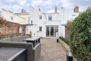 an outdoor patio with a table and a building at Beautiful 4 Bedroom Home in Cheltenham