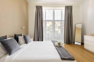 a bedroom with a large white bed with a window at Luxueux appart proche de gare du Midi, à côté du Centre Ville in Brussels