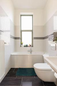 a bathroom with a toilet and a tub and a sink at Luxueux appart proche de gare du Midi, à côté du Centre Ville in Brussels