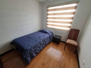 a bedroom with a blue bed and a window at Cómodo y acogedor apartamento in Pasto