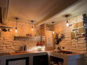 een keuken met een stenen muur en een aanrecht bij La maison St Jean in Honfleur