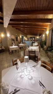 ein Restaurant mit weißen Tischen und Stühlen sowie weißen Tischdecken in der Unterkunft Borgo di Santa Barbara in Santa Domenica