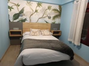 1 dormitorio con 1 cama y una pintura en la pared en Hostal Platerías, en León