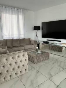 a living room with a couch and a flat screen tv at Appart duplex 87m2 près d’Airbus in Toulouse