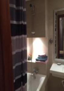 uma casa de banho com uma banheira, um lavatório e um chuveiro em Short Stay Apartment aéroport casablanca em Nouaseur