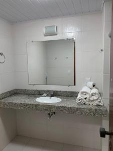 a bathroom with a sink and a mirror and towels at JL Temporadas q 222 PortobelloPark in Porto Seguro +18 photos
