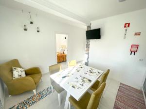 uma sala de jantar com uma mesa branca e cadeiras em Casa Marques na Nazaré